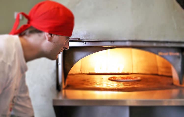 Pizzaiolo cooking Neapolitan pizza during our pizza courses